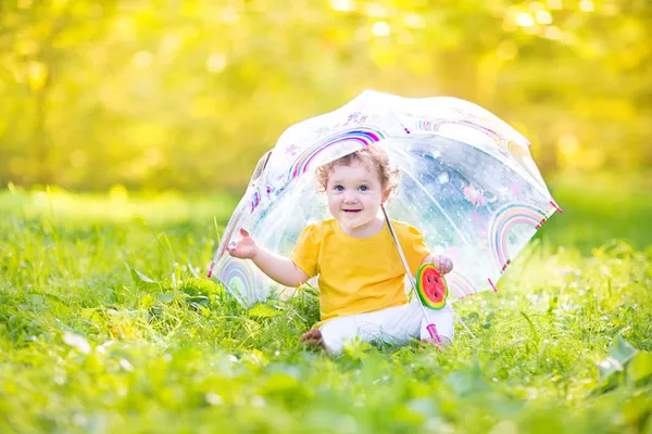 Baby girl under a colorful umbrella — Stock Photo, Image