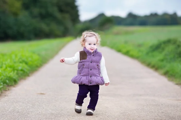 Baby girl running on a country road — Stock Photo, Image