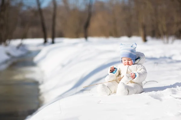 Bebê brincando em um rio nevado — Fotografia de Stock