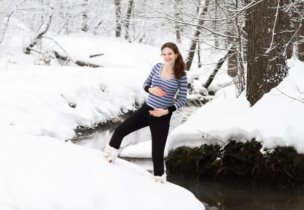 Mulher grávida caminhando ao longo de um rio — Fotografia de Stock