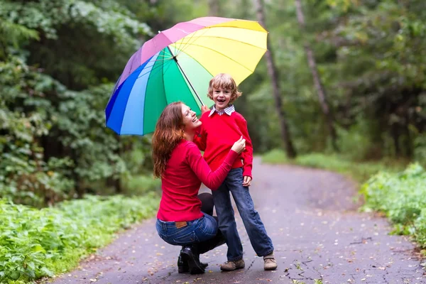 Anne ve oğlu renkli bir şemsiye altında — Stok fotoğraf