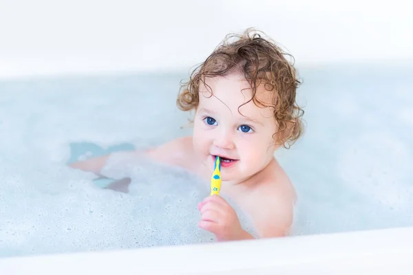 Bébé aux beaux yeux bleus et aux cheveux bouclés prenant son bain — Photo