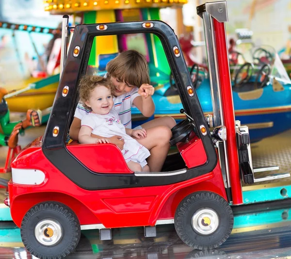 Garçon et sa petite soeur jouissant d'un parc d'attractions — Photo