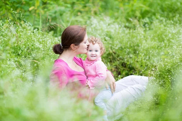 母と、庭でリラックスした彼女の赤ん坊の娘 — ストック写真