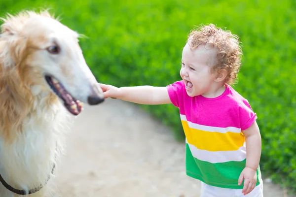 Baby spelen met een grote hond — Stockfoto