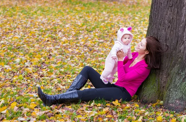 Madre che tiene la sua bambina sotto un albero — Foto Stock