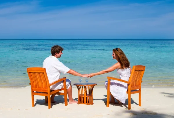 Casal desfrutando de coquetéis em uma praia tropical — Fotografia de Stock