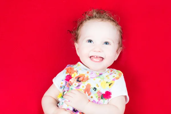 Baby Mädchen in einem floralen farbenfrohen Kleid — Stockfoto
