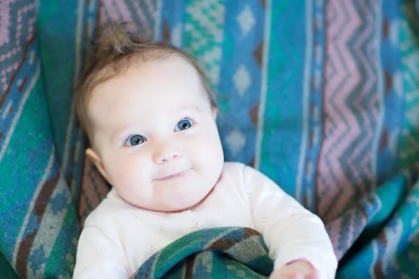 Lachen gelukkig baby onder een warme deken — Stockfoto