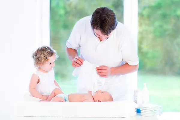 Jonge vader omhoog het kleden van zijn zoon pasgeboren baby — Stockfoto