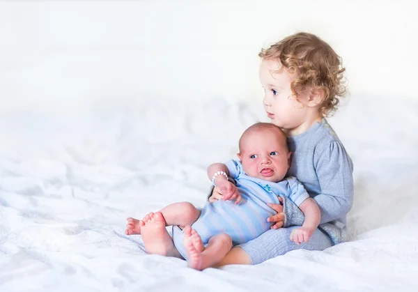 Peuter meisje houdt van haar pasgeboren broertje — Stockfoto