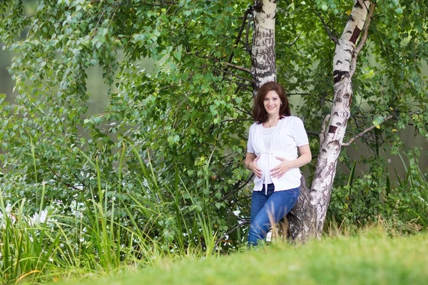 hamile kadın bir Nehri yanındaki bir parkta yürüyüş