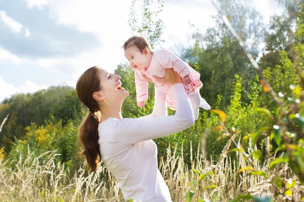 Jonge moeder spelen met haar baby dochter — Stockfoto