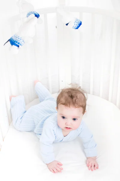 Мила дитина грає в білому круглому ліжку — стокове фото