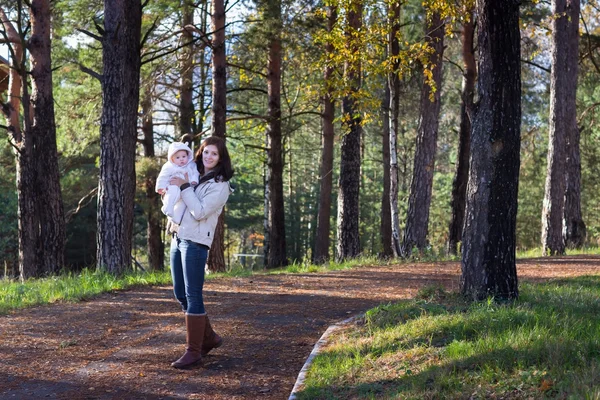 Moeder wandelen met haar baby in een herfst park — Stockfoto