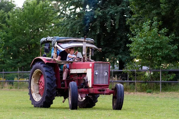 Chico conduciendo un tractor con su abuelo —  Fotos de Stock