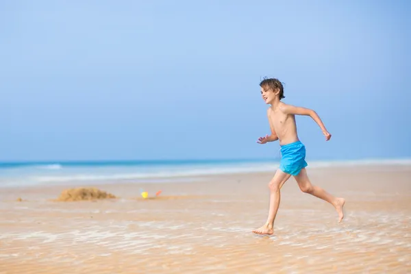 Menino correndo em uma bela praia tropical — Fotografia de Stock