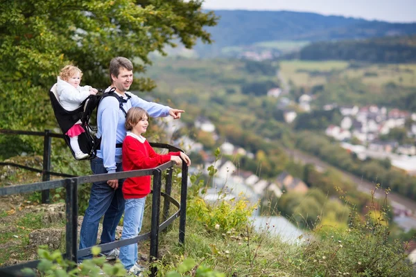 Gelukkige jonge familie wandelen in een mooie herfst bos — Stockfoto