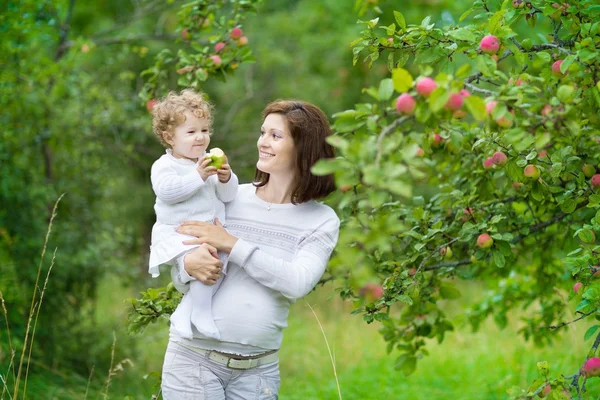 Pregnant woman holding her baby daughter — Stock Photo, Image