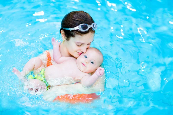 Jonge moeder en baby zoon in een zwembad — Stockfoto