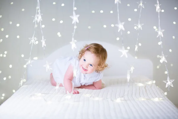 Adorable jeune fille jouant sur un lit — Photo