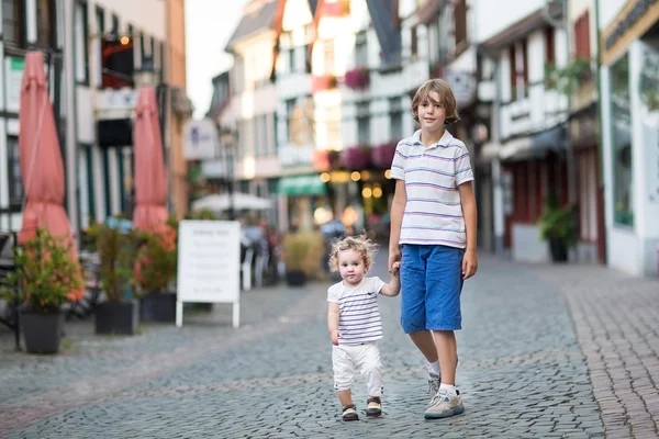哥哥和他的小婴儿妹妹散步、 玩耍在一条购物街 — 图库照片
