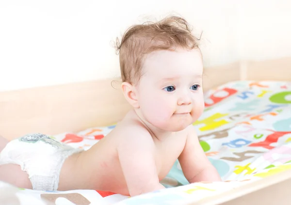 Kleine baby spelen in een bed — Stockfoto