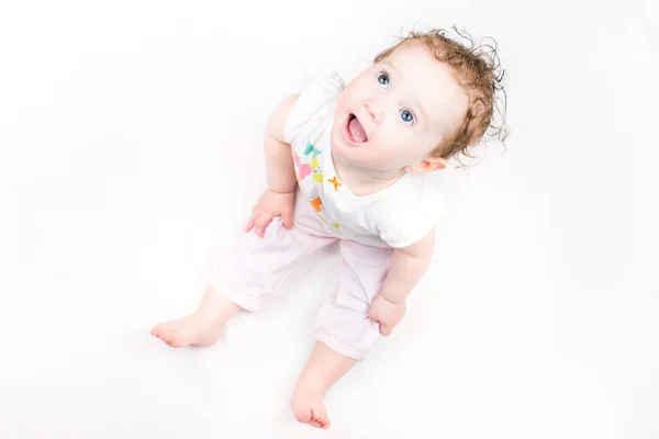 Kleines Mädchen mit lockigem Haar sitzt — Stockfoto