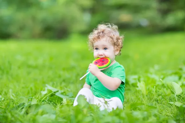 Baby girl eating watermelon candy — Stock Photo, Image