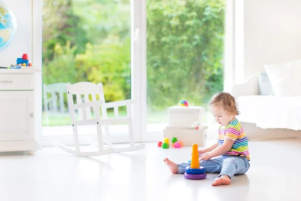 Peuter meisje spelen met een kleurrijke piramide — Stockfoto