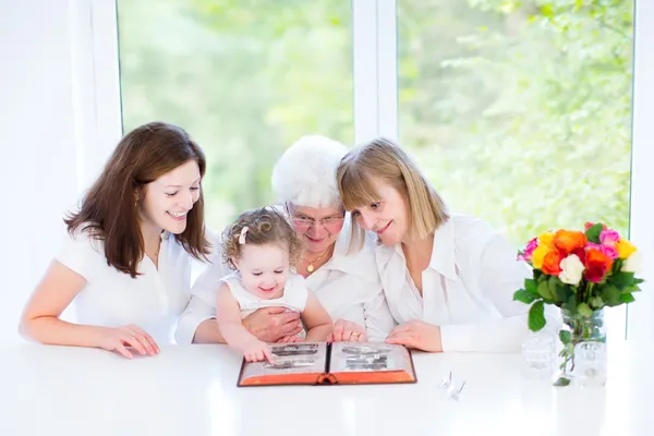 Abuela viendo álbum de fotos con su hija y nietos — Foto de Stock