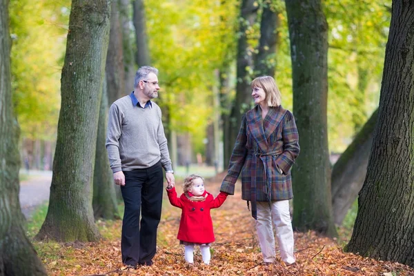 Couple with toddler girl in an autumn park — Stock Photo, Image