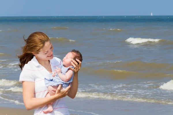 妈妈抱着她刚出生的女儿，在海滩上 — 图库照片