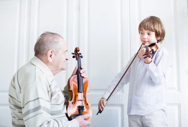 Velké grandfarther poslouchat dítě hrající housle — Stock fotografie