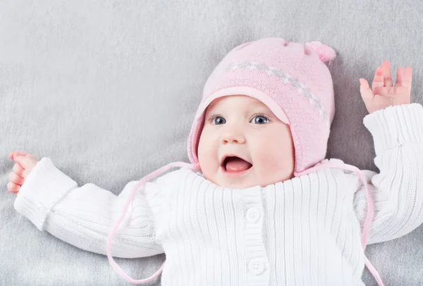 Meisje van de baby in roze gebreide muts — Stockfoto
