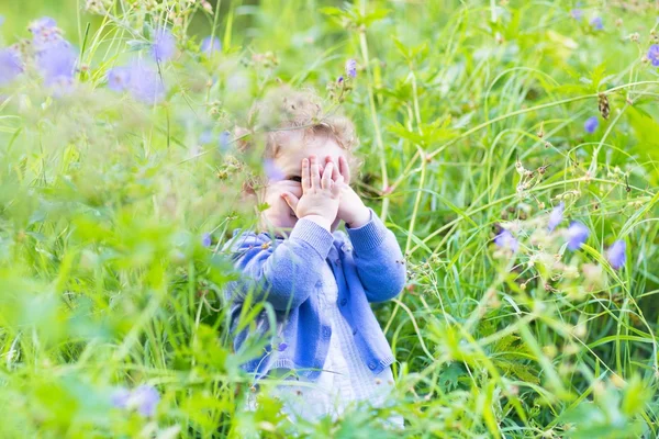 Girl playing hide and seek in the garden