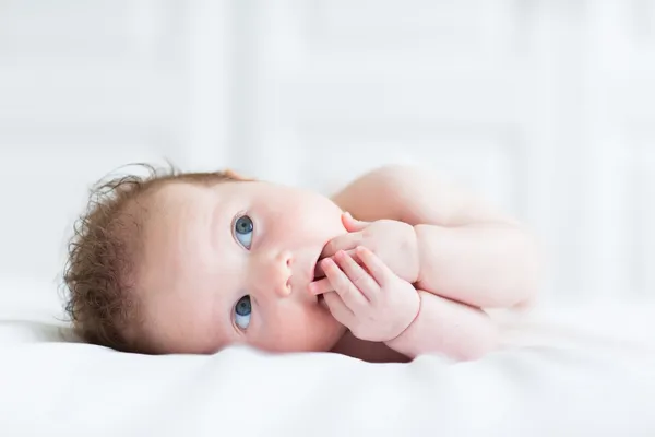 Mavi gözlü bebek onun parmak emme — Stok fotoğraf