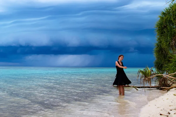 Woman dancing on the beach with a tropical storm — Stock Photo, Image
