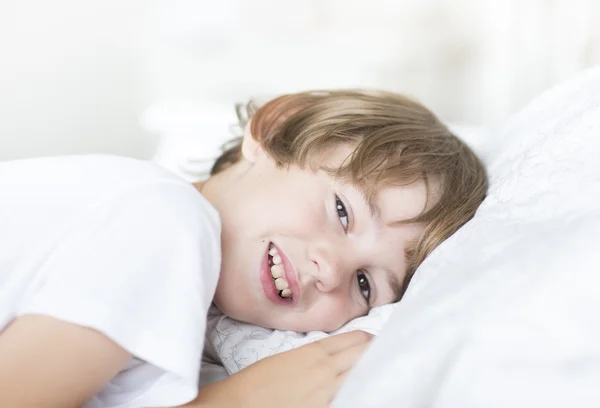 Хлопчик лежить на білій подушці — стокове фото