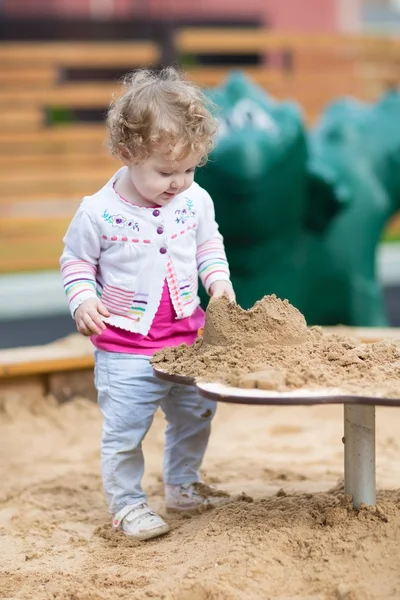 Baby girl playing with sand — Stock Photo, Image