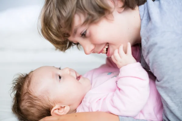 Meisje van de baby lachen naar haar broer — Stockfoto