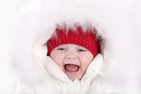 Bebek beyaz kar kıyafeti ve sıcak kırmızı örgü şapka — Stok fotoğraf