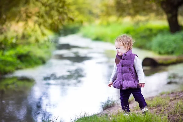Bambina che gioca sulla riva di un fiume — Foto Stock