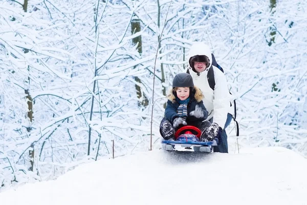 Garçon luge dans un parc enneigé — Photo