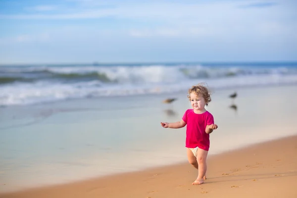 Belle petite fille qui court sur une plage — Photo