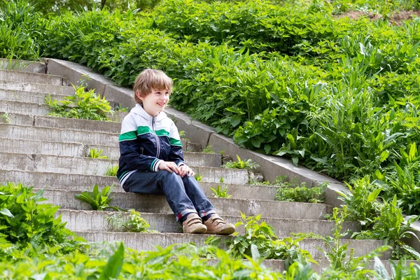 Chlapec hraje na schodech na zahradu — Stock fotografie