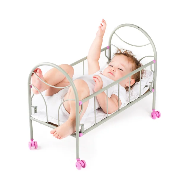 Funny babymeisje spelen in een pop-bed — Stockfoto