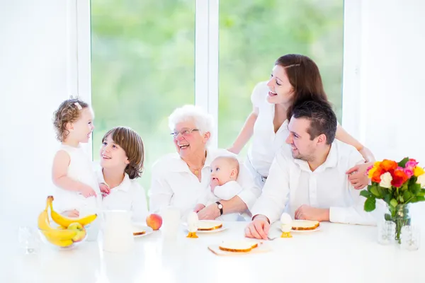 Lykkelig ung familie som morer seg under frokosten – stockfoto