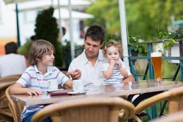 Jonge vader genieten van een maaltijd met zijn zoon en baby dochter — Stockfoto