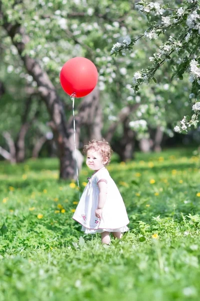 Beautiful little girl playing with flowers — Stock Photo, Image
